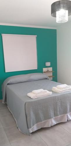 a bedroom with a large bed with a blue wall at Complejo Los Plumerillos in Chascomús