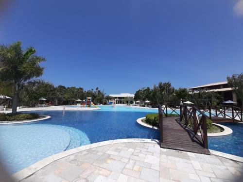 uma grande piscina com um passadiço de madeira num resort em Iloa 3 quartos Luxo na Barra de São Miguel