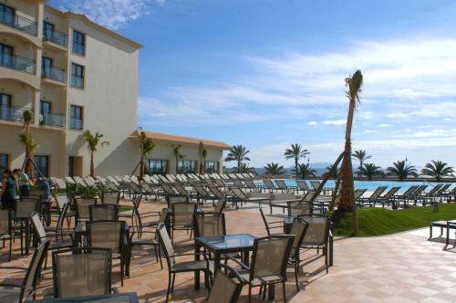 a group of tables and chairs in front of a building at Vila Gale Santa Cruz in Santa Cruz