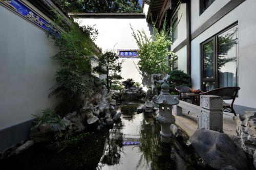 a garden with a pond in front of a building at 福州三坊七巷三宝宾邸 in Fuzhou