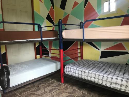 2 literas en una habitación con una pared colorida en Soursop Hostel en Cueta