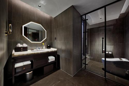 a bathroom with a sink and a shower and a mirror at 福州三坊七巷三宝宾邸 in Fuzhou