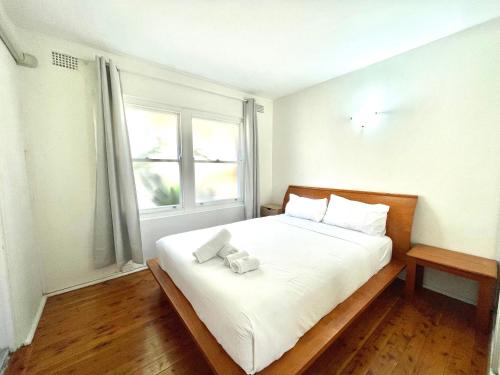 a bedroom with a white bed with two towels on it at Lotus Stay Manly - Apartment 31B in Sydney