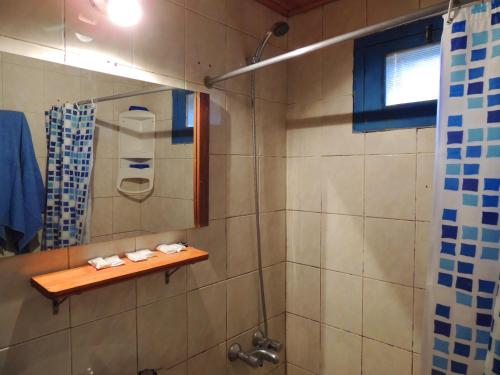 a bathroom with a shower with a wooden shelf at Cabañas San Francisco in Potrerillos