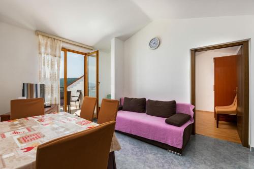 a living room with a purple couch and a table at Apartments Josip in Rabac