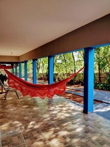 a hammock on a porch with blue poles at Suits - Canto do sabia in Brotas