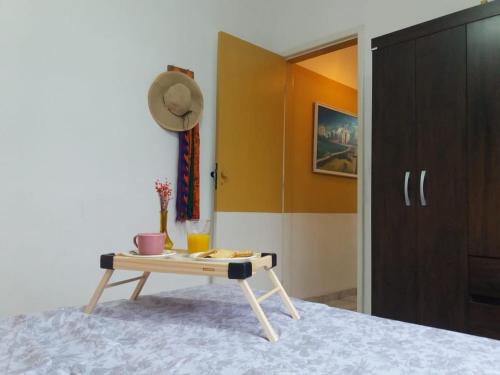 um quarto com uma mesa e um chapéu na cama em Estiloso 2 Quartos Wifi e SmarTV em Guarapari