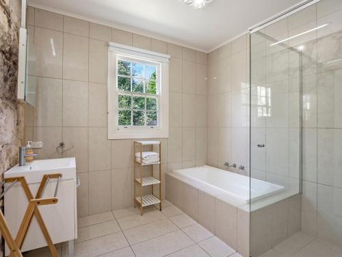 a bathroom with a tub and a shower and a sink at Doran in Port Fairy