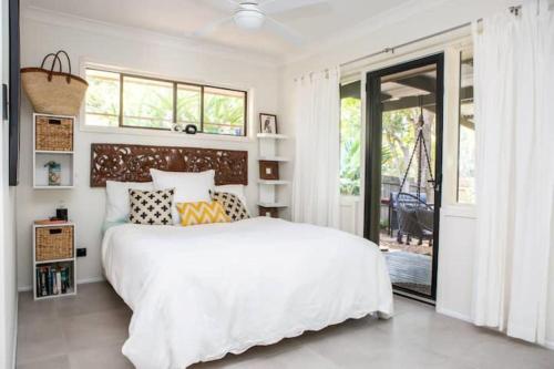 a bedroom with a large white bed and a window at Kookaburras at South Golden - 9min walk to idyllic beach in South Golden Beach