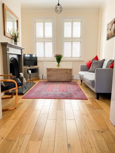 a living room with a couch and a fireplace at Riverside Lodge - Quaint Victorian Home By The River in York