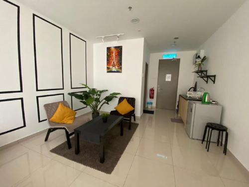 a living room with a table and yellow pillows at Pinnacle PJ @ Penguin Homes in Petaling Jaya