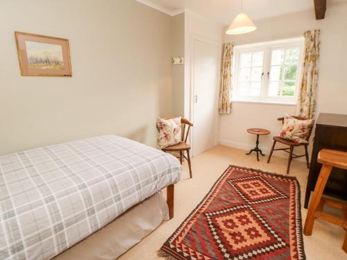 a bedroom with a bed and a table and chairs at Coverdale Cottage in Carlton