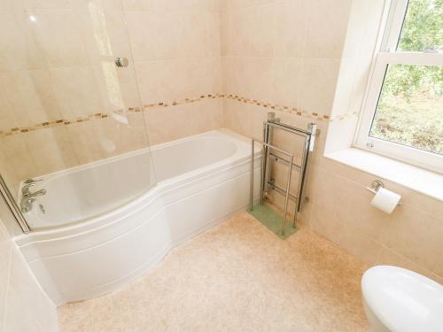 a bathroom with a tub and a toilet and a sink at Coverdale Cottage in Carlton