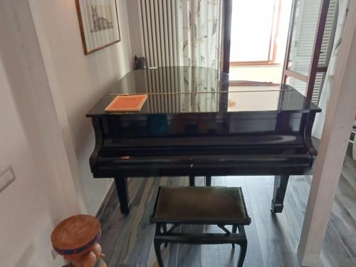 a piano with a chair next to a window at Sguardo sul lago in Trevignano Romano