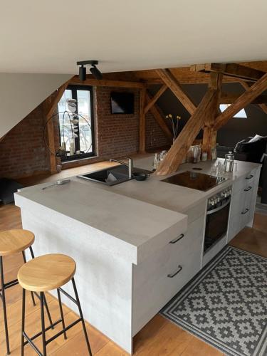 a kitchen with a counter with a sink and stools at Ferienhaus in Bleicherode in Bleicherode