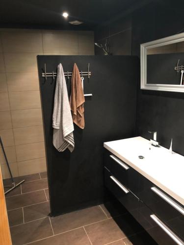 Baño negro con lavabo y lavabo blanco en City Center Enschede Homestay, en Enschede