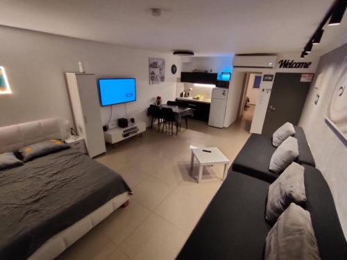 a bedroom with a bed and a living room with a television at דירות נופש וג'קוזי באילת - אילן vip in Eilat