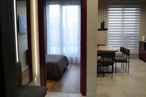 Schlafzimmer mit einem Bett, einem Tisch und Stühlen in der Unterkunft Kostjukowski apartments Nekrasova 45a in Lwiw