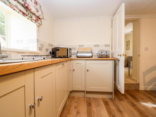 a kitchen with white cabinets and a counter top at The Clock Tower in South Cerney