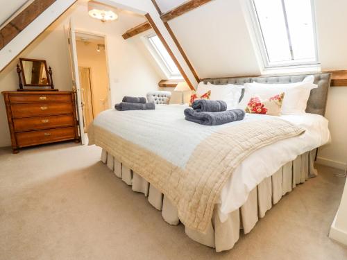a bedroom with a large bed with towels on it at The Clock Tower in South Cerney