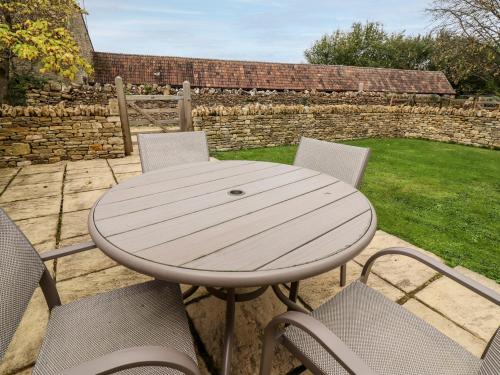a wooden table and chairs on a patio at The Clock Tower in South Cerney