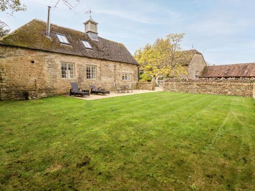 an old stone house with a large yard at The Clock Tower in South Cerney