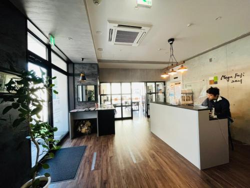 a man is standing at a counter in a room at Megu Fuji 2021 in Fujiyoshida