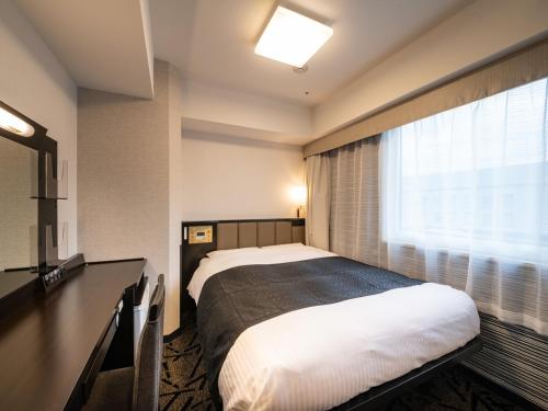 um quarto de hotel com uma cama e uma janela em APA Hotel Akihabara Ekihigashi em Tóquio