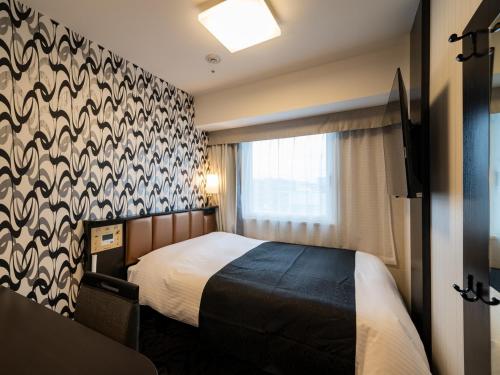 une chambre d'hôtel avec un lit et une fenêtre dans l'établissement APA Hotel Akihabara Ekihigashi, à Tokyo