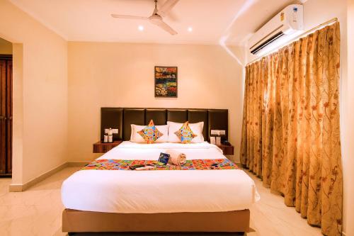 a bedroom with a large bed and a large window at FabHotel Blossoms Service Apartment in Chennai