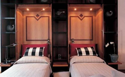 two beds in a room with red headboards at Casa Cuniolo Guest House in Tortona