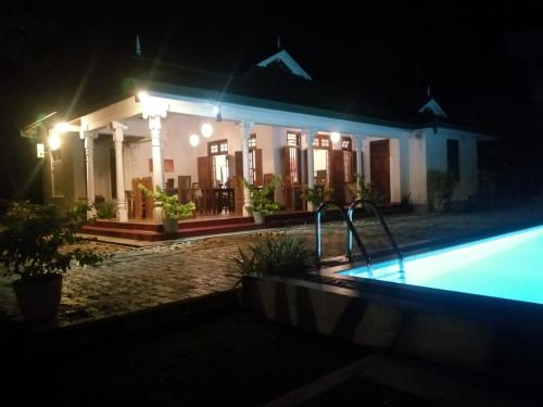 a house with a swimming pool at night at Tranquility guest house in Hikkaduwa