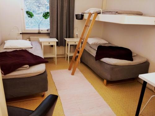 a room with two bunk beds and a ladder at Laholms Vandrarhem in Laholm