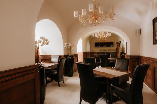 Un comedor con mesas y sillas y una lámpara de araña. en Hotel Bonaparte, en Košice