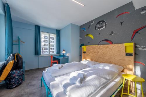 a bedroom with a bed and a wall with planets at MEININGER Hotel Innsbruck Zentrum in Innsbruck
