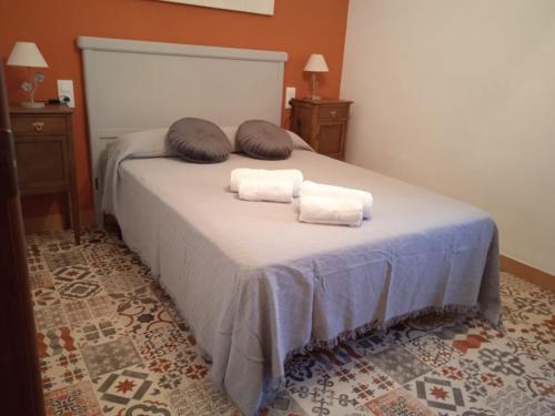 ein Bett mit zwei Kissen und zwei Handtüchern darauf in der Unterkunft Casa Tòfol in Catí