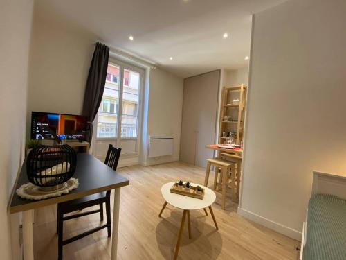 a living room with a table and a dining room at Place de Metz, Hyper-centre Grenoble, Studio 25 m2 in Grenoble