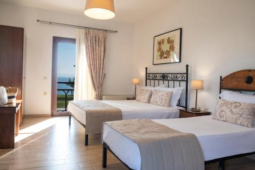a hotel room with two beds and a balcony at Aegean Blue Horizon in Afitos