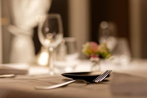 una mesa con un plato y un tenedor sobre una mesa en Le Grand Cerf en Nonancourt