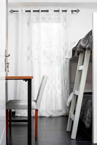a bedroom with a desk and a bed and a window at Filippos Acharnes Elegance in Akharnaí
