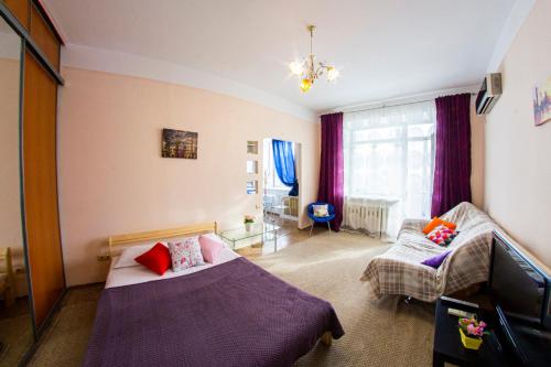 オムスクにあるRENT-сервис Apartment on Maslennikova 9のベッドルーム(ベッド1台、ソファ付)