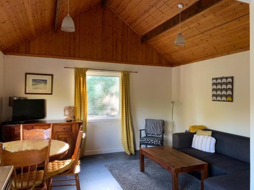 ein Wohnzimmer mit einem Sofa und einem Tisch in der Unterkunft Creity Hall Chalet in Stirling