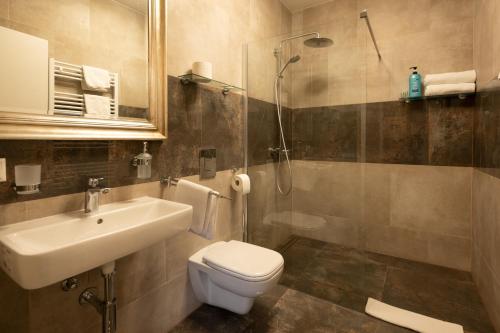 a bathroom with a toilet, sink, and bathtub at Hotel Burgblick in Bonn