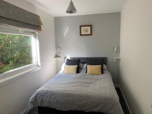 Bett in einem Schlafzimmer mit Fenster in der Unterkunft Creity Hall Chalet in Stirling