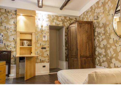 a bedroom with a bed and a kitchen with wallpaper at Relais Santa Chiara in Naples