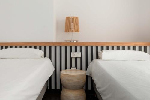 ein Zimmer mit zwei Betten und einer Lampe an der Wand in der Unterkunft Ereza Hoopoe Villas in Playa Blanca
