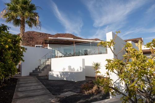 ein weißes Haus mit einer Palme und einer Treppe in der Unterkunft Ereza Hoopoe Villas in Playa Blanca