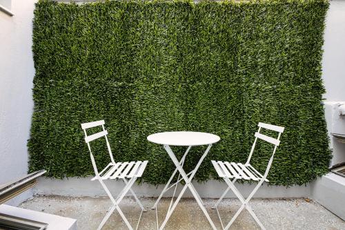 two chairs and a table in front of a green wall at Filippos Acharnes in Akharnaí