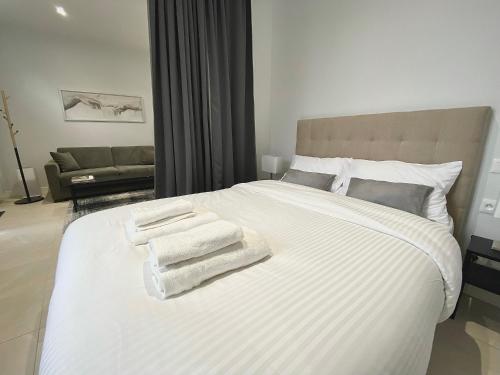 a bedroom with a white bed with towels on it at ShineAppart Marmande Centre in Marmande