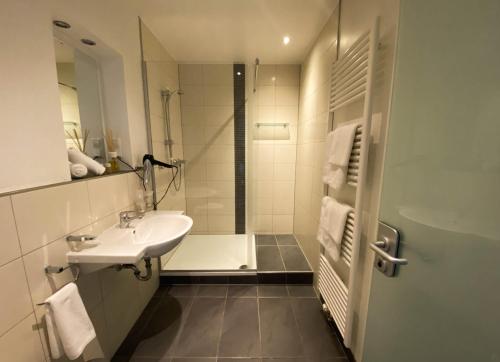a white bathroom with a sink and a shower at Villa Bassermann in Schwetzingen